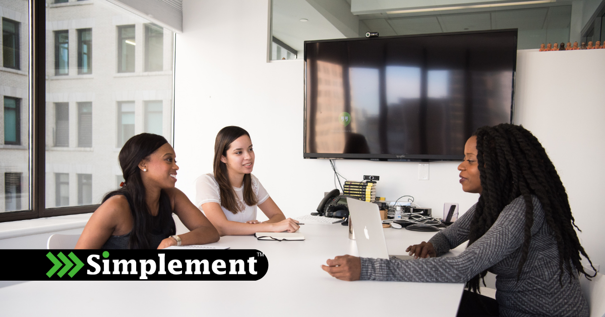 3 women in a business setting or large office, HR meeting, simplement logo